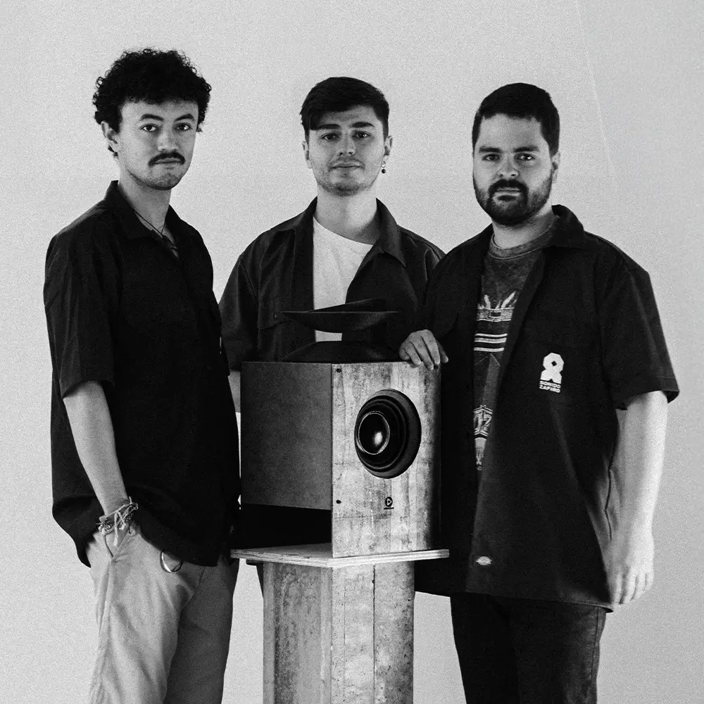 Los fundadores de Decibelio posando junto al prototipo del sistema Woofer Assisted Wideband (WAW), representando la ingeniería y diseño detrás de la marca.